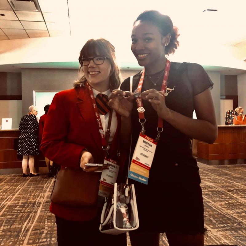 Kimmie Aiken, left, and Mikiyah Ennals show off their pins. Mikiyah is modeling the jumper she constructed from an old pair of men’s overalls.